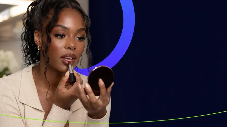A creator applying lipstick with a compact mirror