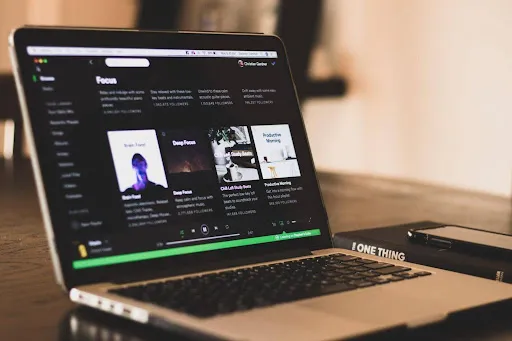 Laptop on a desk showing Spotify's Focus playlist page